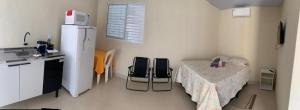 a kitchen with a table and two chairs in a room at Casa Studio Uirá - rua dos Cravos in Chapada dos Guimarães
