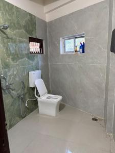 a bathroom with a toilet and a shower at LN Homes in Itānagar +5 photos