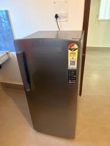 a metal refrigerator is sitting in a room at LN Homes in Itānagar