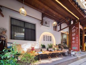 a restaurant with tables and chairs in front of a building at JINGJING·YUNXI·WEITANG HOTEL in Zhangjiajie