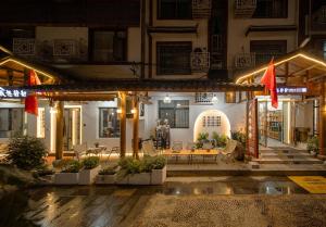 a building with a patio at night at JINGJING·YUNXI·WEITANG HOTEL in Zhangjiajie