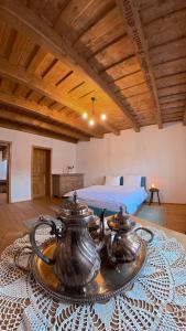 a room with a bed and two tea pots on a table at Azuria Viscri in Viscri