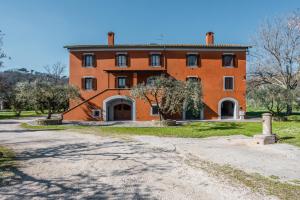 an orange building with a driveway in front of it at Agriturismo i Due Casini in Riano