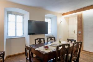 a dining room with a table with chairs and a flat screen tv at oasi del relax in Scopello