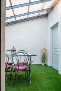 a patio with a table and chairs on grass at oasi del relax in Scopello