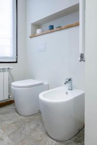 a white bathroom with a toilet and a sink at oasi del relax in Scopello