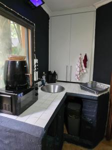 a kitchen with a sink and a microwave at The Pot in Pretoria +72 photos