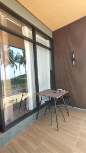 a dining room with a table and a large window at Denis cozy homestay in Senaru