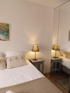 a bedroom with two beds and a mirror at Hypercentre Strasbourg Vue Cathédrale in Strasbourg