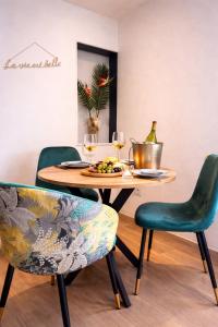 a table with a plate of food and wine glasses at Appartement Oiseau du Paradis avec terrasse parking privé proche centre in Moulins