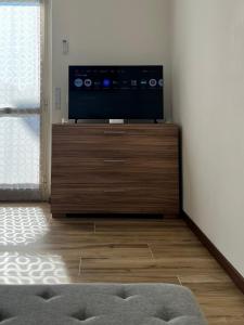 a flat screen tv sitting on top of a wooden stand at Easy Bergamo Apartment in Bergamo