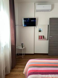 a bedroom with a bed and a tv on the wall at Easy Bergamo Apartment in Bergamo