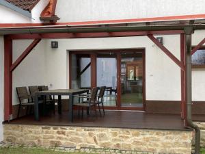 a patio with a table and chairs on a deck at Ubytování pod Nadymákem in Telč
