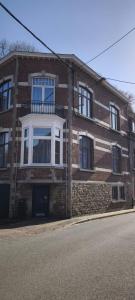 a brick building with a white window on a street at Résidence Bayard in Dinant