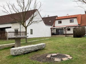 a house with a bench and a tree in a yard at Ubytování pod Nadymákem in Telč