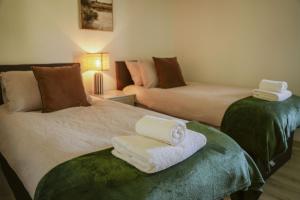 a room with two beds with towels on a seat at Oak Lodge in Knighton