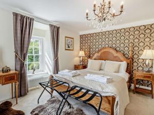 a bedroom with a large bed and a chandelier at 5 Bed in Machynlleth oc-92513 in Machynlleth