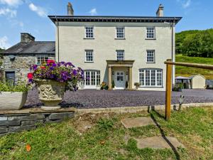 a large house with flowers in front of it at 5 Bed in Machynlleth oc-92513 in Machynlleth
