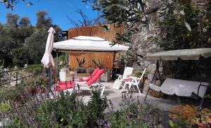 a patio with chairs and an umbrella and a table at Agriturismo I Pipetta in Levanto