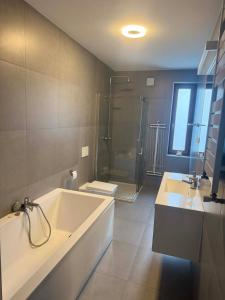 a bathroom with a tub and two sinks and a shower at TOBI-pokoje gościnne in Łeba +92 photos
