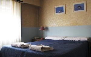 a bedroom with a blue bed with towels on it at Hotel City in Trelew