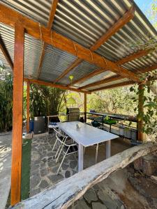 a picnic table under a wooden pergola at Casa Avi Fauna Nature Guesthouse Y Casa AlmaCalma in Ocotal