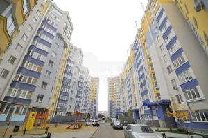 a group of tall buildings with cars parked in a street at Buicani Confort Stay in Chişinău