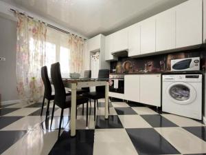 a kitchen with a table and chairs and a washing machine at Buicani Confort Stay in Chişinău