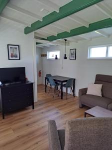 a living room with a table and a couch at Zeeuws Wagenhuys in Biggekerke
