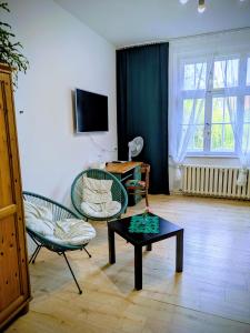 a living room with two chairs and a coffee table at Pokoje Rybnicka 10 in Katowice