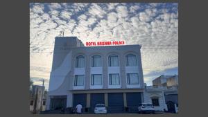 a white building with a sign on the top of it at Hotel Krishna Palace in Sirohi
