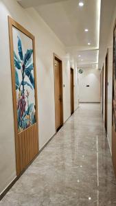 a hallway with wooden doors and a painting on the wall at Hotel Krishna Palace in Sirohi