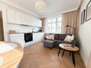 a living room with a couch and a table at Jaśminowy Apartament in Sławno