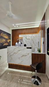 a man is standing at a counter in a room at Hotel Krishna Palace in Sirohi