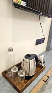 a tea kettle and glasses on a wooden tray at Hotel Krishna Palace in Sirohi