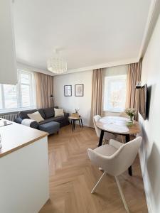 a kitchen and living room with a table and a couch at Jaśminowy Apartament in Sławno