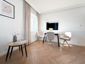 a living room with a table and chairs and a tv at Jaśminowy Apartament in Sławno +1 photo