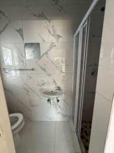 a white bathroom with a sink and a toilet at Black & White Guest House in Parow