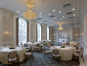 a banquet room with tables and chairs and a chandelier at The Lord Nelson Hotel & Suites in Halifax