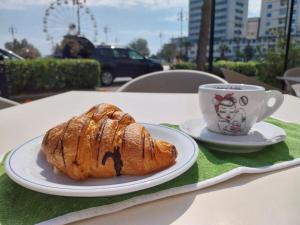 a pastry and a cup of coffee on a table at Hotel Cristallo Cesenatico in Cesenatico