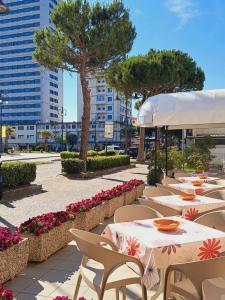 a row of tables and chairs in a courtyard with flowers at Hotel Cristallo Cesenatico in Cesenatico