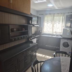 a kitchen with black cabinets and a table with chairs at Résidence du golf in Fez