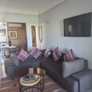 a living room with a couch and a flat screen tv at Résidence du golf in Fez +7 photos