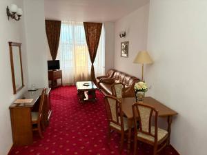 a living room with a couch and a table at Hotel Emma West in Craiova