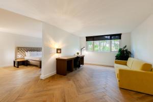 a bedroom with a bed and a desk and a couch at Parasasa Hotel Curacao in Willemstad