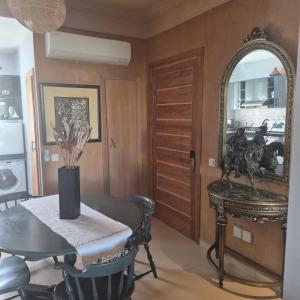 a dining room with a table and a mirror at Résidence du golf in Fez