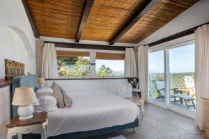 a bedroom with a bed and a balcony with windows at Hotel Balocco in Porto Cervo +153 photos