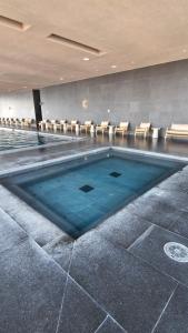 a swimming pool with chairs in a building at Stylish Loft for 4 Reforma CDMX Ideal Long Stay in Mexico City