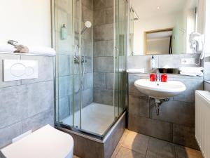 a bathroom with a shower and a toilet and a sink at DORMERO Hotel Aalen in Aalen +31 photos