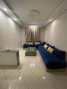 a living room with a blue couch and a table at Apparemment BAHRA in Taza